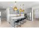 Bright kitchen features gray cabinets, stainless steel appliances, a large island with seating and modern pendant lights at 13227 Spring Grove Way, Winter Garden, FL 34787