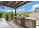 Outdoor kitchen featuring a stainless steel grill, granite countertops and beverage cooler at 13227 Spring Grove Way, Winter Garden, FL 34787