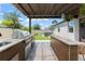 Outdoor kitchen under a pergola, featuring stainless steel grill and adjacent hot tub at 13227 Spring Grove Way, Winter Garden, FL 34787