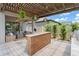 Outdoor kitchen and living area with pergola, featuring a tiled bar and comfortable seating at 13227 Spring Grove Way, Winter Garden, FL 34787