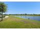 Community pond featuring trees, grass, and an open space for recreation at 13227 Spring Grove Way, Winter Garden, FL 34787
