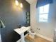 Stylish powder room features a pedestal sink, mosaic tile wall, and natural light at 1341 Lumpini St, St Cloud, FL 34771