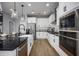 Modern kitchen features white cabinets, stainless steel appliances, and black countertops at 1341 Lumpini St, St Cloud, FL 34771