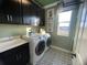 Well-lit laundry room with modern washer and dryer, sink, and stylish black and white tile flooring at 1341 Lumpini St, St Cloud, FL 34771