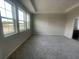 Bright bedroom featuring carpet, three large windows, and neutral gray walls at 1354 Twelve Oaks Rd, St Cloud, FL 34771