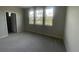 This bedroom features carpet flooring, three bright windows, and neutral walls at 1354 Twelve Oaks Rd, St Cloud, FL 34771