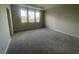 Carpeted bedroom with three large windows offering natural light, and neutral-toned walls at 1354 Twelve Oaks Rd, St Cloud, FL 34771