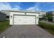 This home features a two-car garage with brick-paved driveway at 1354 Twelve Oaks Rd, St Cloud, FL 34771