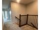 Upstairs landing with neutral carpet, wood railing, and hallway leading to additional bedrooms at 1354 Twelve Oaks Rd, St Cloud, FL 34771