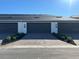 Exterior of townhouse garages with black doors and brick-paved driveways bordered by manicured landscaping at 1356 Lumpini St, St Cloud, FL 34771