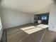 Spacious, unfinished living room featuring a view to the kitchen and a large window providing ample natural light at 1356 Lumpini St, St Cloud, FL 34771