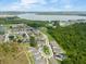 A scenic aerial view shows a neighborhood near a lake, with lush green landscaping and beautiful blue skies at 1382 Foltz Loop, Oakland, FL 34787
