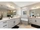 Elegant bathroom with double vanities, a soaking tub, and contemporary fixtures at 1382 Foltz Loop, Oakland, FL 34787