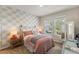 Cozy bedroom featuring patterned wallpaper, comfortable bed, and bright natural light at 1382 Foltz Loop, Oakland, FL 34787