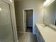 Bathroom featuring a modern vanity, walk-in closet, and glass-enclosed shower, offering style and functionality at 1411 Mount Royal Dr, St Cloud, FL 34771