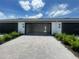 Pavered driveway leads to an open garage and landscaped entryway, enhancing curb appeal at 1411 Mount Royal Dr, St Cloud, FL 34771