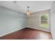Cozy bedroom with hardwood floors, a ceiling light, and a window overlooking the backyard at 1413 Brookebridge Dr, Orlando, FL 32825