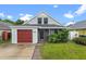 Charming home with a red garage door, inviting front porch, and lush landscaping at 1413 Brookebridge Dr, Orlando, FL 32825