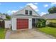 Charming home with a red garage door, inviting front porch, and lush landscaping at 1413 Brookebridge Dr, Orlando, FL 32825