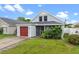 Charming home with a red garage door, inviting front porch, and lush landscaping at 1413 Brookebridge Dr, Orlando, FL 32825