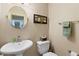 Half bathroom featuring pedestal sink, round mirror, picture frame, and light green hand towel at 14612 Bray Rd, Orlando, FL 32832