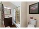Bathroom with a tiled shower, dark wood vanity, and framed art with dark brown rug at 14612 Bray Rd, Orlando, FL 32832