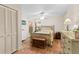 Comfortable bedroom with wood floors, a ceiling fan, natural light, and a chest at the foot of the bed at 14612 Bray Rd, Orlando, FL 32832