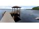 Scenic view of a wooden dock with a covered gazebo extending into a calm lake at 14612 Bray Rd, Orlando, FL 32832