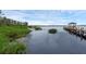 Picturesque lake view showcasing calm waters, natural vegetation, and a distant gazebo at 14612 Bray Rd, Orlando, FL 32832