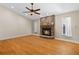 Cozy living room featuring hardwood floors, a brick fireplace, and natural light from the windows at 14612 Bray Rd, Orlando, FL 32832