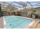 An inviting screened-in pool with a dolphin mosaic and an outdoor kitchen and dining space at 14612 Bray Rd, Orlando, FL 32832