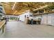Well-lit workshop with exposed wood ceiling beams, storage, and space for various projects at 14612 Bray Rd, Orlando, FL 32832