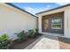 Close-up of the home's entryway, showcasing a wooden front door with glass panels and manicured landscaping at 14930 Sw 66Th Ave Rd, Ocala, FL 34473
