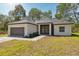Charming single-story home featuring a gray brick walkway, a two-car garage, and well-manicured landscaping at 14930 Sw 66Th Ave Rd, Ocala, FL 34473