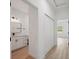 Hallway view showing a half bathroom with vanity, a bi-fold closet, and an adjacent bedroom at 14930 Sw 66Th Ave Rd, Ocala, FL 34473