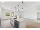 A stylish kitchen featuring a large island with quartz countertops and stainless steel appliances at 14930 Sw 66Th Ave Rd, Ocala, FL 34473