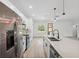 Modern kitchen boasts a large island with quartz countertops and stainless steel appliances at 14930 Sw 66Th Ave Rd, Ocala, FL 34473
