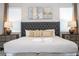 Bedroom featuring tufted headboard, coordinated lamps, and cozy linens offer a luxurious retreat at 1505 Nassau Point Trl, Kissimmee, FL 34747