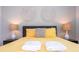 Bright bedroom featuring a comfortable bed with decorative wall art, lamps, and soft linens at 1505 Nassau Point Trl, Kissimmee, FL 34747