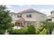Charming tan two-story home with a brick driveway and a two-car garage surrounded by mature trees and landscaping at 1505 Nassau Point Trl, Kissimmee, FL 34747