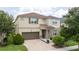 Charming two-story home featuring a brown roof, stone accents, a two-car garage, and a well-manicured front yard at 1505 Nassau Point Trl, Kissimmee, FL 34747