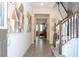 Inviting foyer featuring neutral tiles, staircase with decorative railings, and modern artwork enhancing the entrance's aesthetic at 1505 Nassau Point Trl, Kissimmee, FL 34747