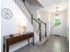 Welcoming foyer featuring neutral tile flooring, staircase with carpeted steps, and a stylish wooden console table with a lamp at 1505 Nassau Point Trl, Kissimmee, FL 34747