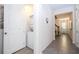 Hallway with gray tile flooring featuring a stacked washer and dryer, leading to a door with a view of the front yard at 1505 Nassau Point Trl, Kissimmee, FL 34747