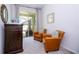 Cozy living room with comfortable leather armchairs, elegant dark wood furniture, and natural light from the sliding glass doors at 1505 Nassau Point Trl, Kissimmee, FL 34747