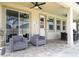 Relaxing covered patio with stylish seating and a view to the outdoor space at 1505 Nassau Point Trl, Kissimmee, FL 34747