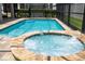 Inviting pool and spa with clear water and tiled surround in screened in enclosure at 1505 Nassau Point Trl, Kissimmee, FL 34747