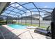 Sparkling pool and spa with lounge chairs, enclosed in a screened lanai at 1505 Nassau Point Trl, Kissimmee, FL 34747
