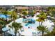 Aerial view of the community's water park featuring a splash pad, slides, and palm trees for a fun, tropical experience at 1505 Nassau Point Trl, Kissimmee, FL 34747