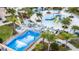 Aerial view of a wave pool with a yellow slide, cabanas, seating areas, and palm trees at 1505 Nassau Point Trl, Kissimmee, FL 34747